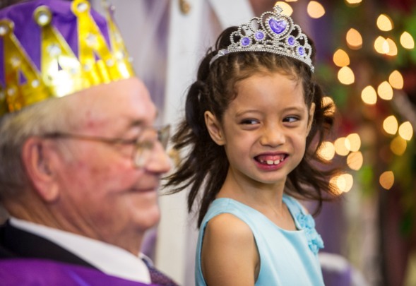 Arthur Elementary School first grader Ariel Her smiles at the school's namesake Matt Arthur, Prince Charming, while having her photo made during the school's Cinderella Ball.